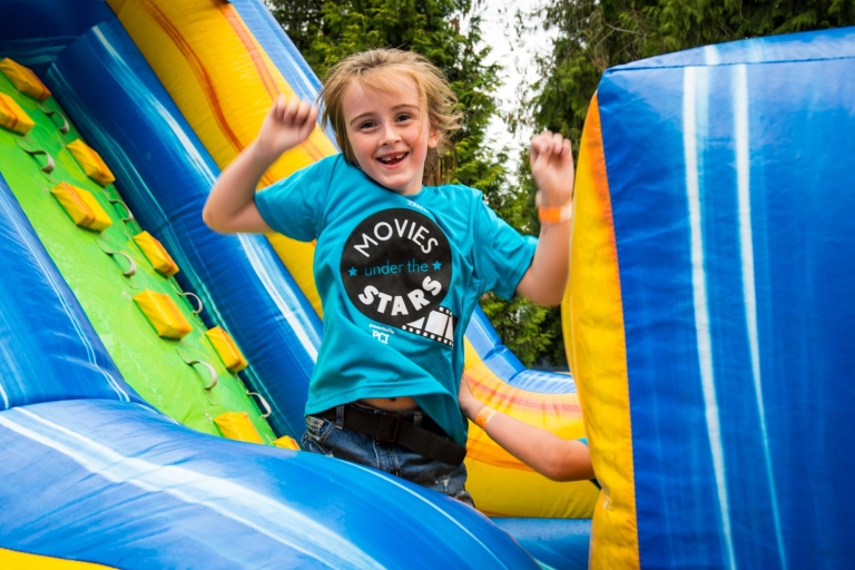 A child smiling on an inflatable.