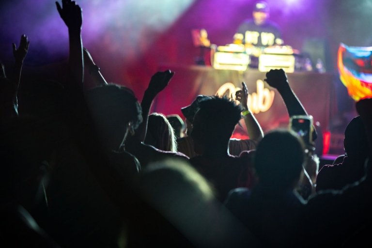 People with their hands up at a concert.