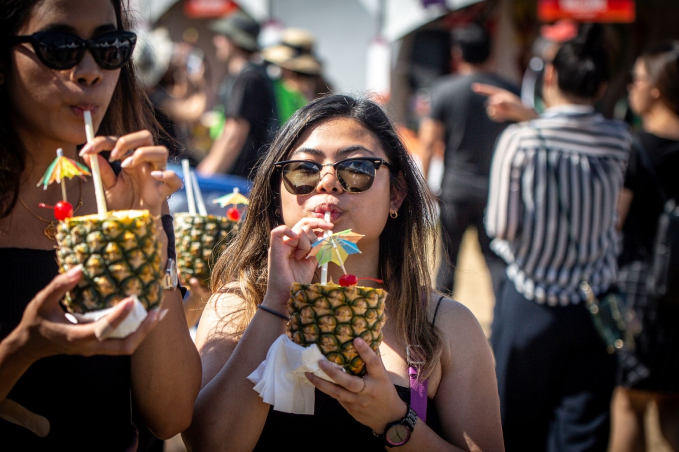 A girl holding a pineapple drink.